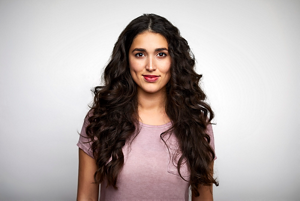 Beautiful woman with long curly brown hair wearing a pink t-shirt